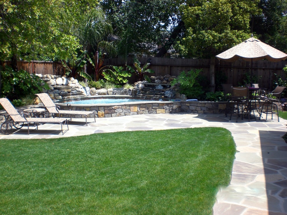 Small traditional backyard custom-shaped natural pool in San Francisco with natural stone pavers and a water feature.