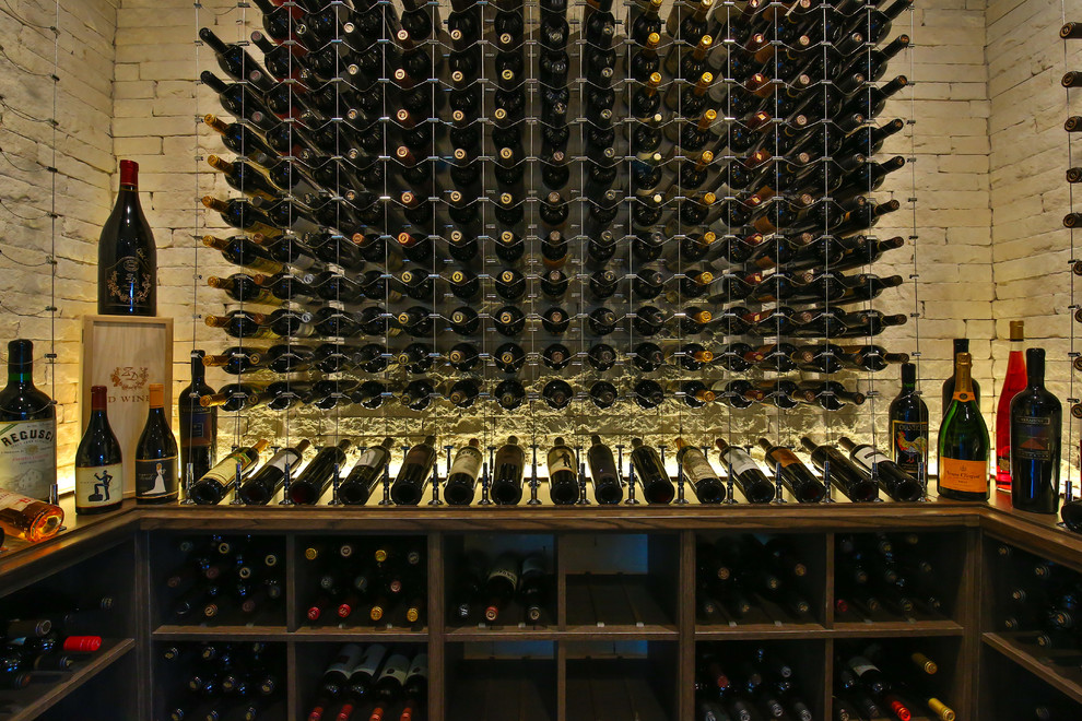 This is an example of a large contemporary wine cellar in Dallas with storage racks, carpet and beige floor.