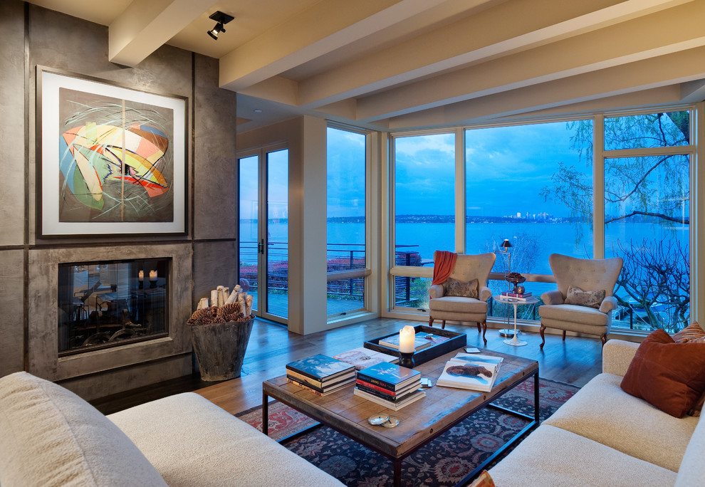 This is an example of a contemporary living room in Seattle with medium hardwood floors and a two-sided fireplace.