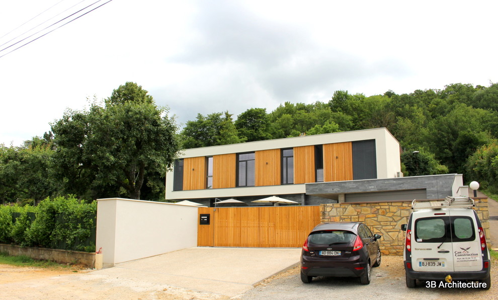 Inspiration pour une grande façade de maison grise design en bois à un étage avec un toit plat et un toit végétal.
