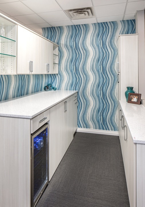 Mid-sized transitional galley dedicated laundry room in Omaha with an undermount sink, flat-panel cabinets, grey cabinets, terrazzo benchtops, blue splashback, blue walls, carpet, a side-by-side washer and dryer, grey floor and white benchtop.