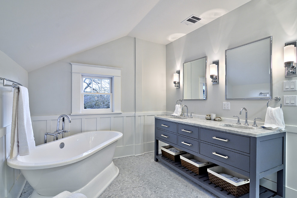 This is an example of a mid-sized traditional master bathroom in Austin with a freestanding tub, marble benchtops, gray tile, blue cabinets and flat-panel cabinets.