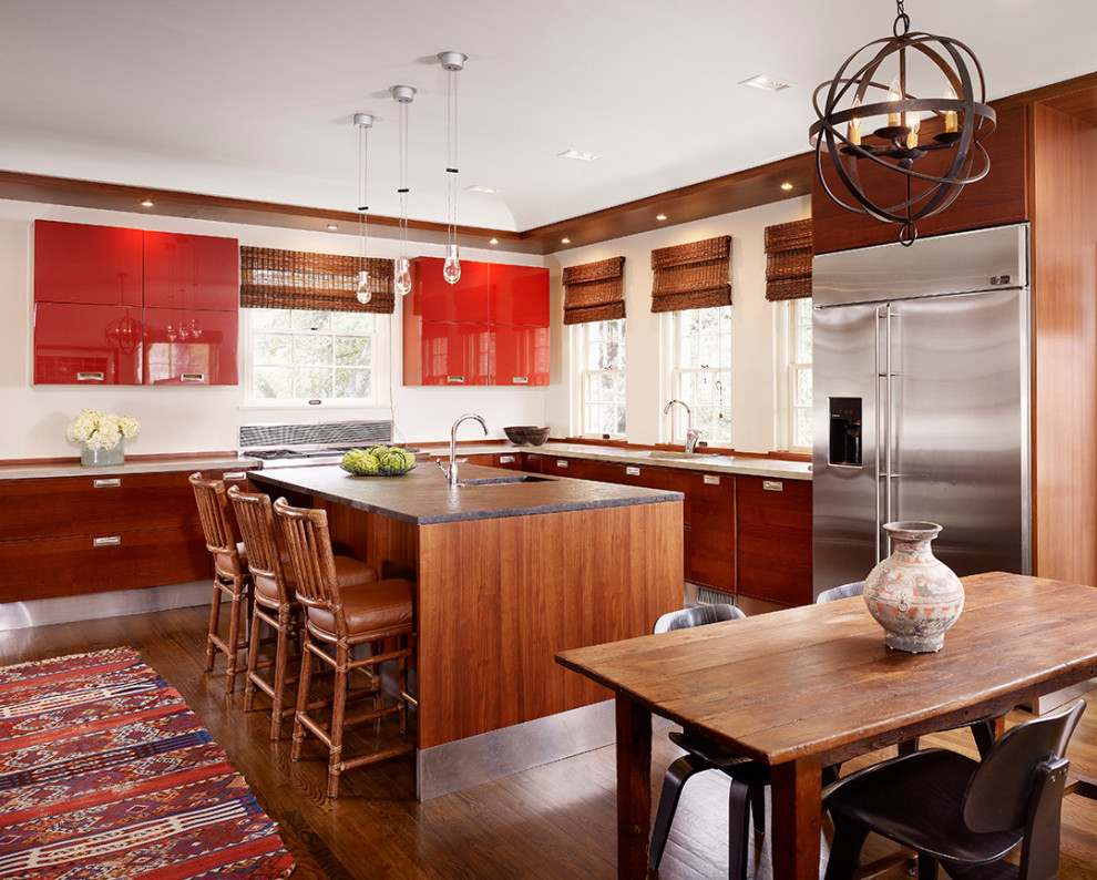 Photo of a mediterranean l-shaped eat-in kitchen in Austin with flat-panel cabinets, dark hardwood floors, with island, brown floor, red cabinets and grey benchtop.