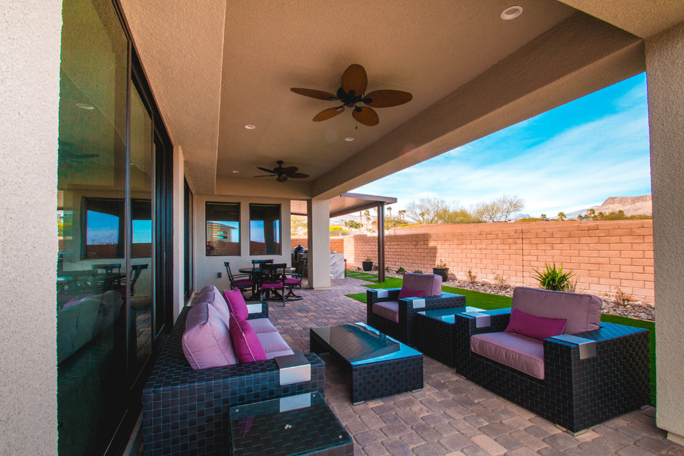 Large contemporary backyard patio in Las Vegas with an outdoor kitchen, brick pavers and an awning.