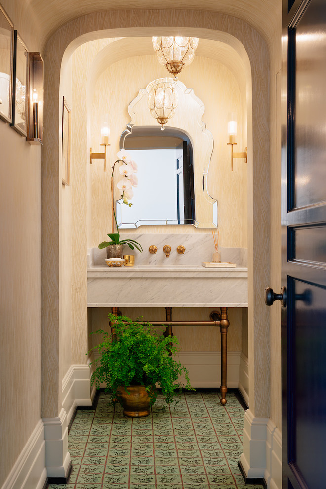 Photo of a mid-sized contemporary powder room in Los Angeles with beige walls, porcelain floors, an undermount sink and marble benchtops.