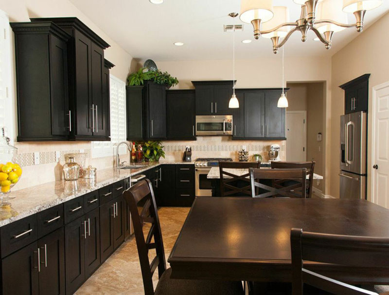 Inspiration for a mid-sized transitional l-shaped porcelain tile eat-in kitchen remodel in Phoenix with an undermount sink, shaker cabinets, black cabinets, granite countertops, beige backsplash, stone tile backsplash, stainless steel appliances and an island