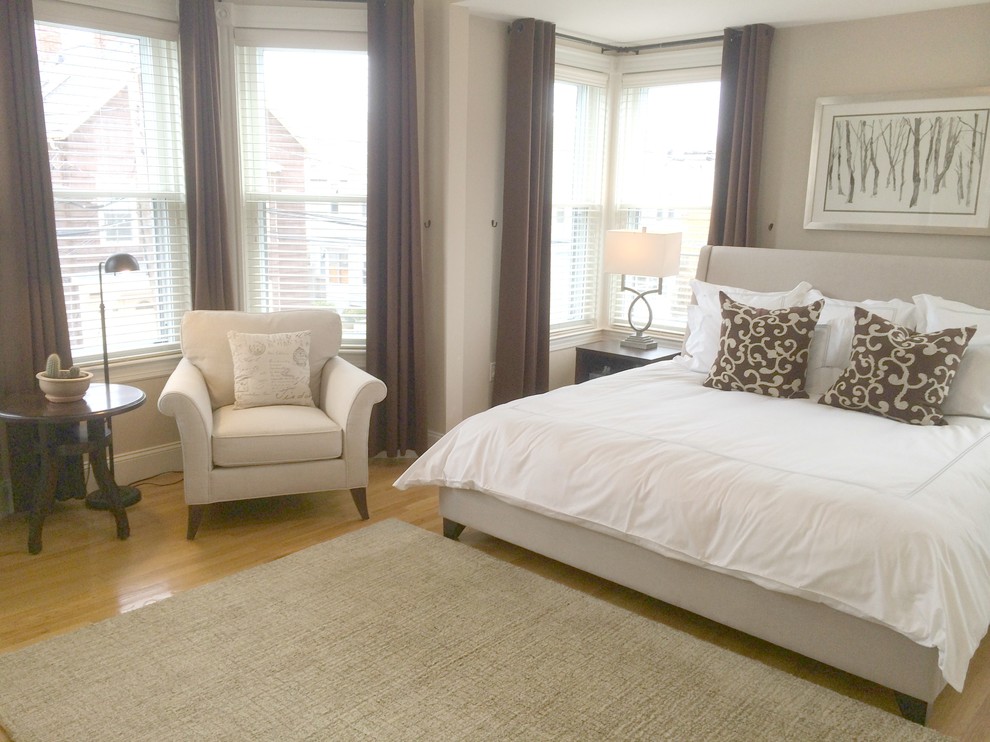 Inspiration for a mid-sized transitional master bedroom in Boston with beige walls and light hardwood floors.