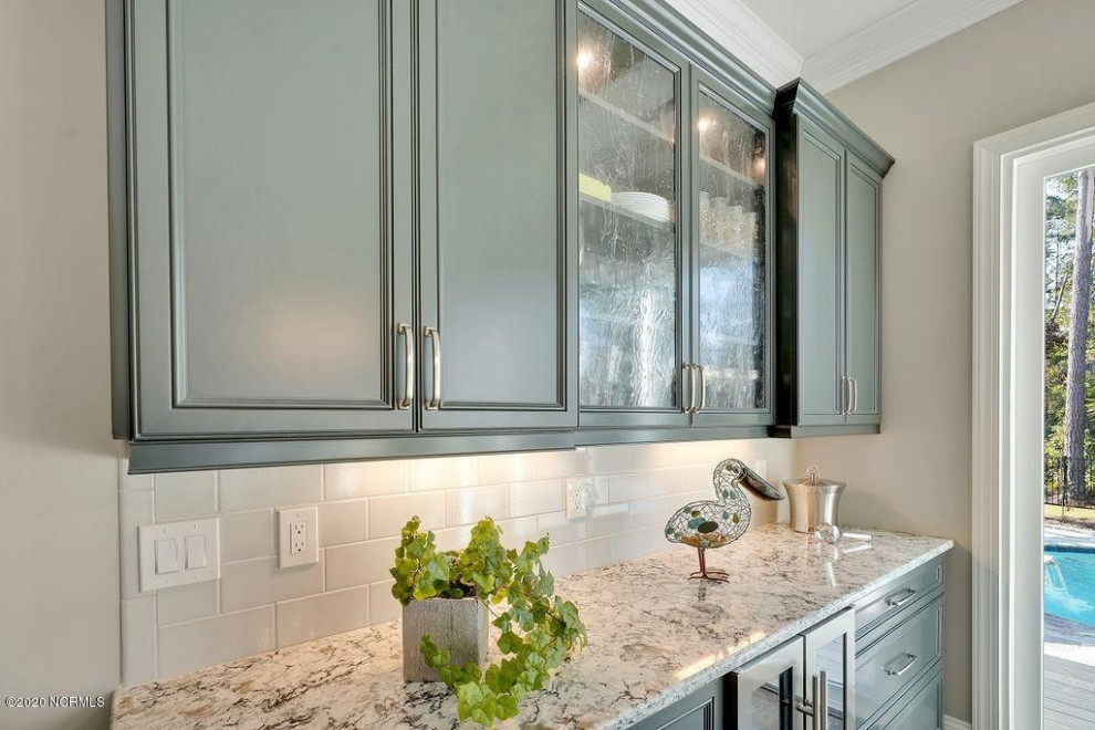 Example of a mid-sized transitional dry bar design in Wilmington with recessed-panel cabinets, green cabinets, granite countertops, white backsplash, porcelain backsplash and multicolored countertops