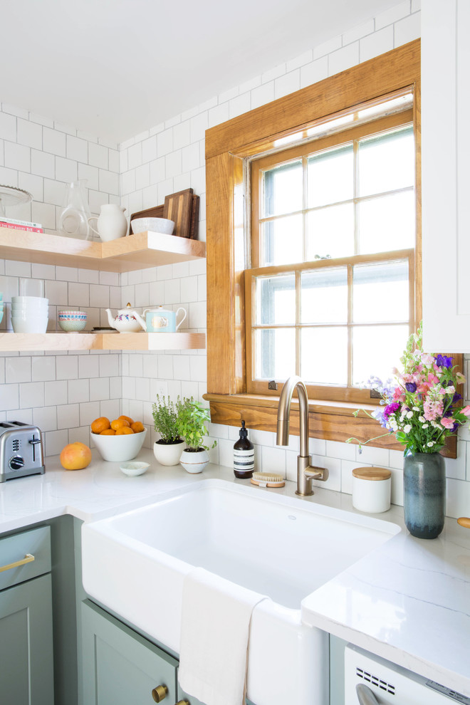 Eat-in kitchen - small transitional u-shaped medium tone wood floor and brown floor eat-in kitchen idea with a farmhouse sink, shaker cabinets, blue cabinets, quartz countertops, white backsplash, porcelain backsplash, white appliances and a peninsula