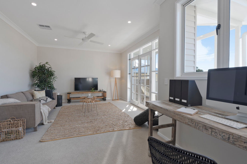 Photo of a mid-sized beach style enclosed family room in Sunshine Coast with a game room, beige walls, carpet, a freestanding tv and beige floor.