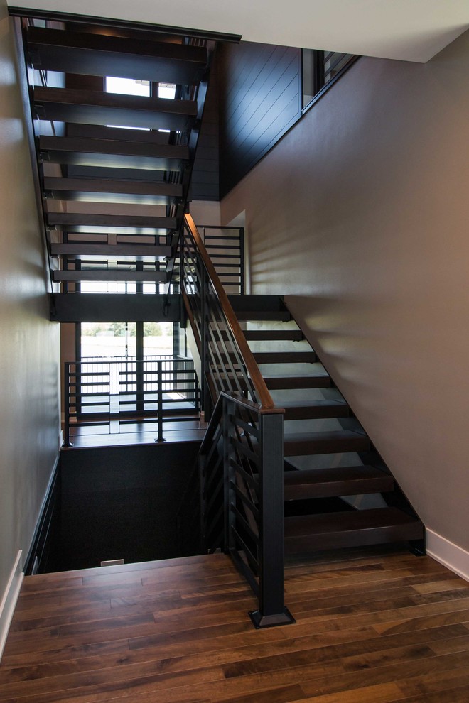 Photo of a large modern wood floating staircase in Other with open risers and metal railing.