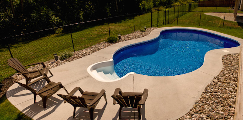 Mid-sized backyard concrete and freeform pool photo