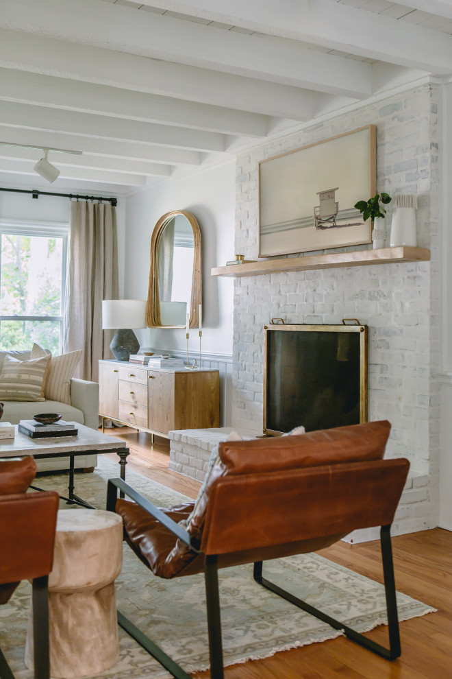Mid-sized mediterranean formal enclosed living room in Raleigh with white walls, medium hardwood floors, a standard fireplace, a brick fireplace surround, a wall-mounted tv, yellow floor, wood and panelled walls.