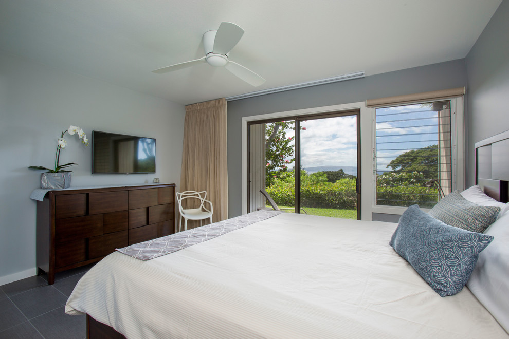 This is an example of a transitional master bedroom in Hawaii with grey walls and porcelain floors.