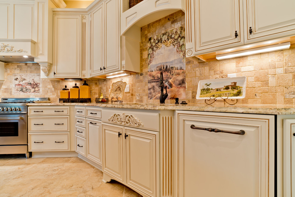 Photo of a large mediterranean u-shaped eat-in kitchen in Miami with an undermount sink, raised-panel cabinets, white cabinets, granite benchtops, beige splashback, porcelain splashback, stainless steel appliances, porcelain floors and with island.