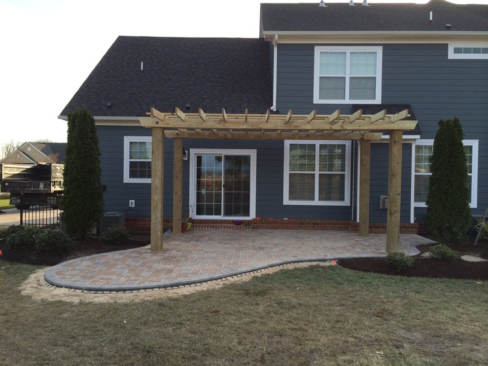 Design ideas for a mid-sized traditional backyard patio in Other with a fire feature, concrete pavers and a pergola.