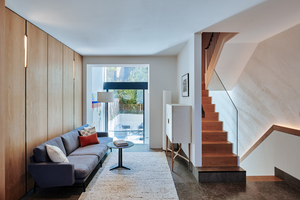 Immagine di un grande soggiorno minimalista aperto con pareti bianche, pavimento in pietra calcarea, pavimento grigio e pannellatura