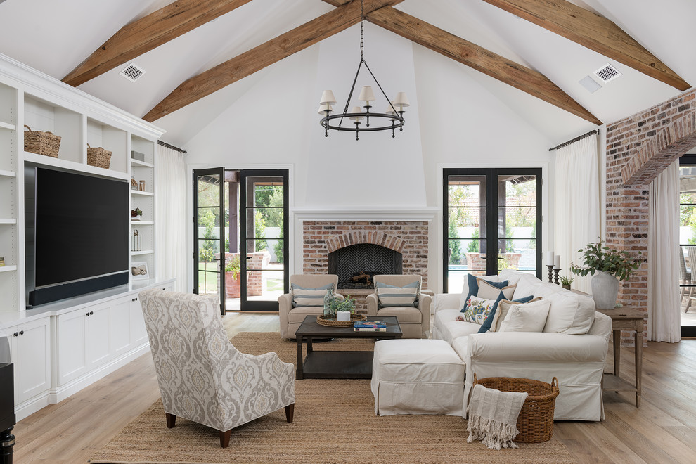 This is an example of a transitional enclosed living room in Phoenix with white walls, medium hardwood floors, a standard fireplace, a built-in media wall, brown floor and a brick fireplace surround.