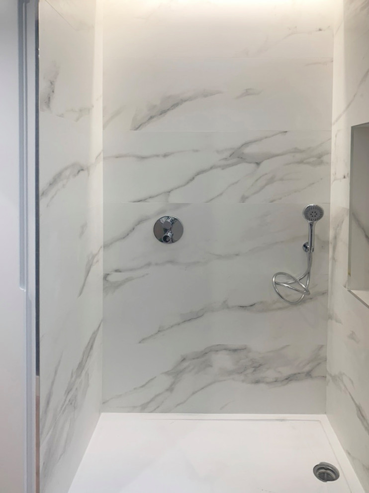 Modern inredning av ett badrum, med en dusch i en alkov och marmorkakel