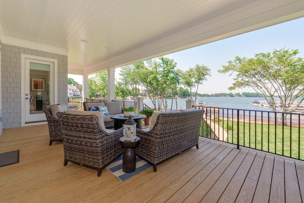 Inspiration for a large beach style backyard patio in Charlotte with decking and a roof extension.