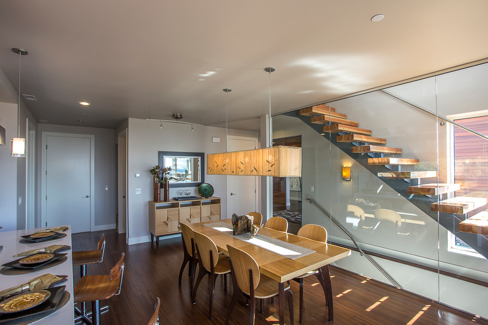 This is an example of a contemporary kitchen/dining combo in Seattle with grey walls and dark hardwood floors.