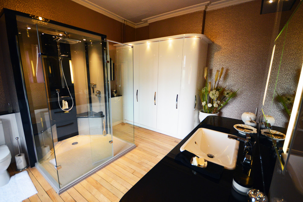 This is an example of a large contemporary kids bathroom in Other with a drop-in sink, furniture-like cabinets, white cabinets, solid surface benchtops, a double shower, a one-piece toilet and light hardwood floors.