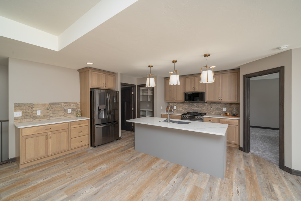 Example of a transitional l-shaped vinyl floor and multicolored floor eat-in kitchen design with shaker cabinets, light wood cabinets, quartz countertops, beige backsplash, an island and white countertops