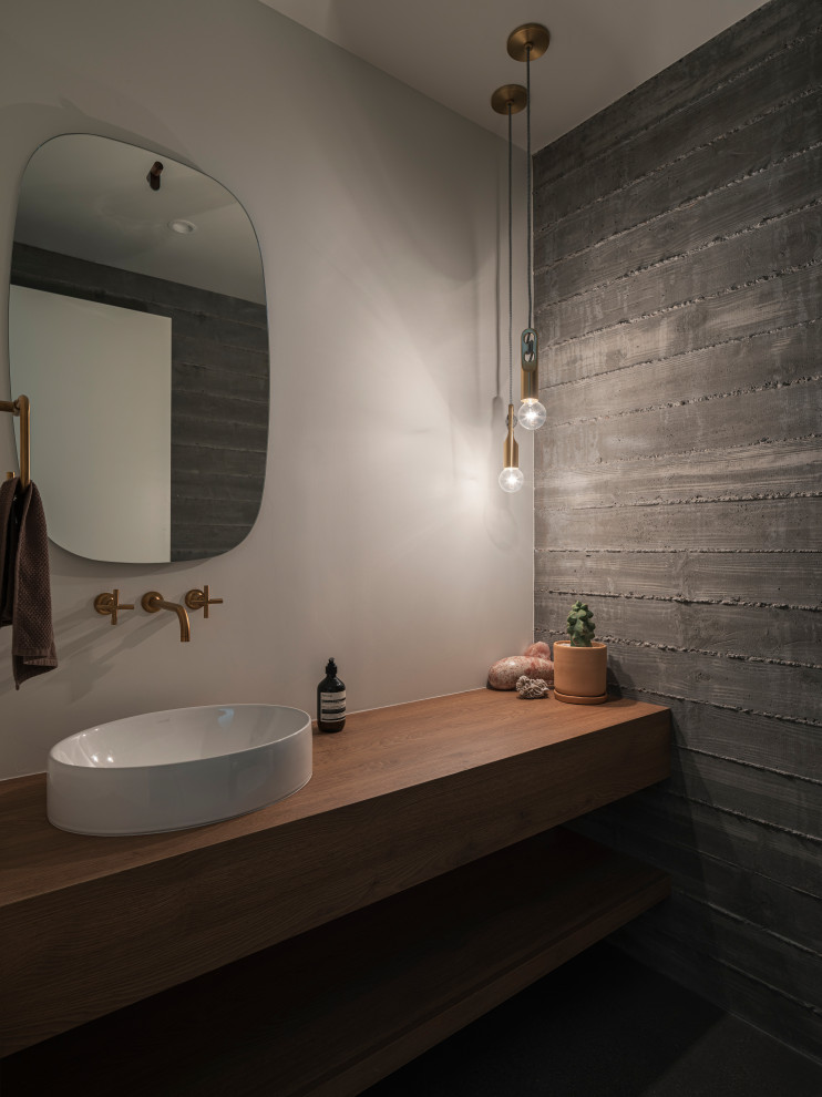 Immagine di un bagno di servizio minimalista con lavabo a bacinella, top in legno e mobile bagno sospeso