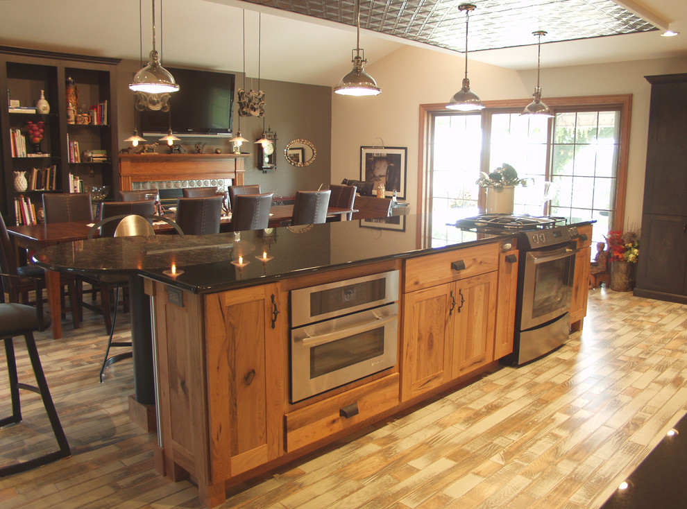 Kitchen - rustic kitchen idea with flat-panel cabinets, light wood cabinets, granite countertops, stainless steel appliances and an island