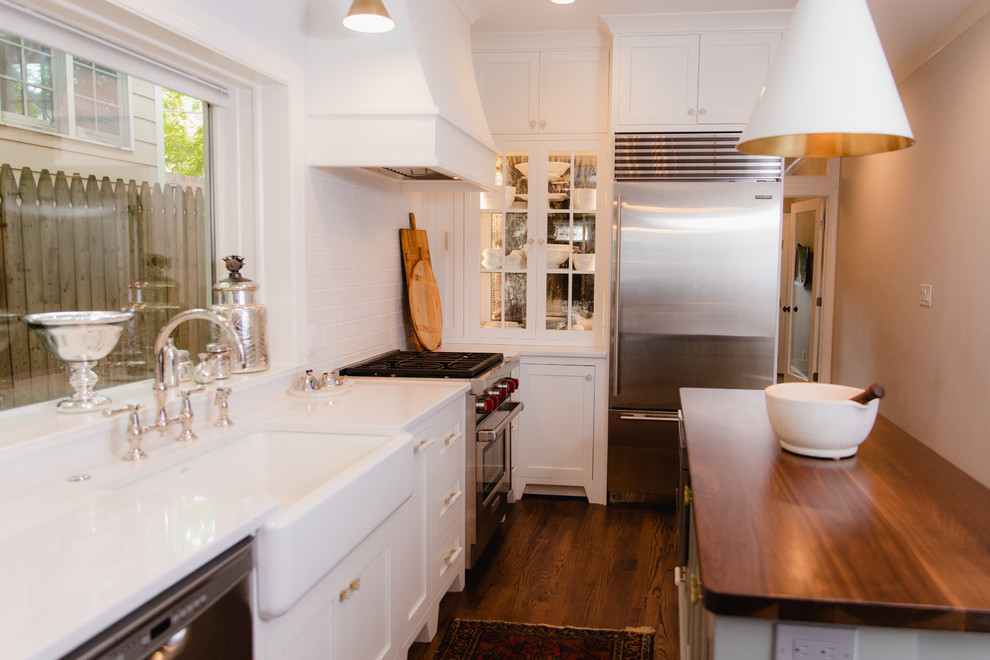 Design ideas for a small transitional l-shaped eat-in kitchen in Baltimore with a farmhouse sink, shaker cabinets, white cabinets, quartz benchtops, white splashback, cement tile splashback, stainless steel appliances, dark hardwood floors, with island, brown floor and white benchtop.