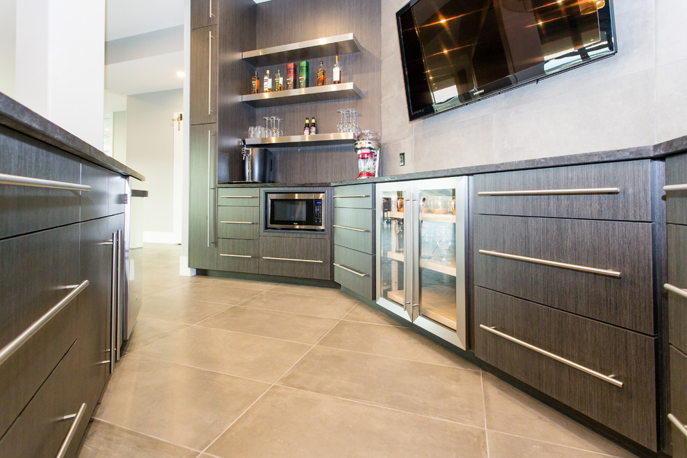 Photo of a large contemporary u-shaped seated home bar in Calgary with an undermount sink, flat-panel cabinets, brown cabinets, granite benchtops, grey splashback, vinyl floors and brown floor.