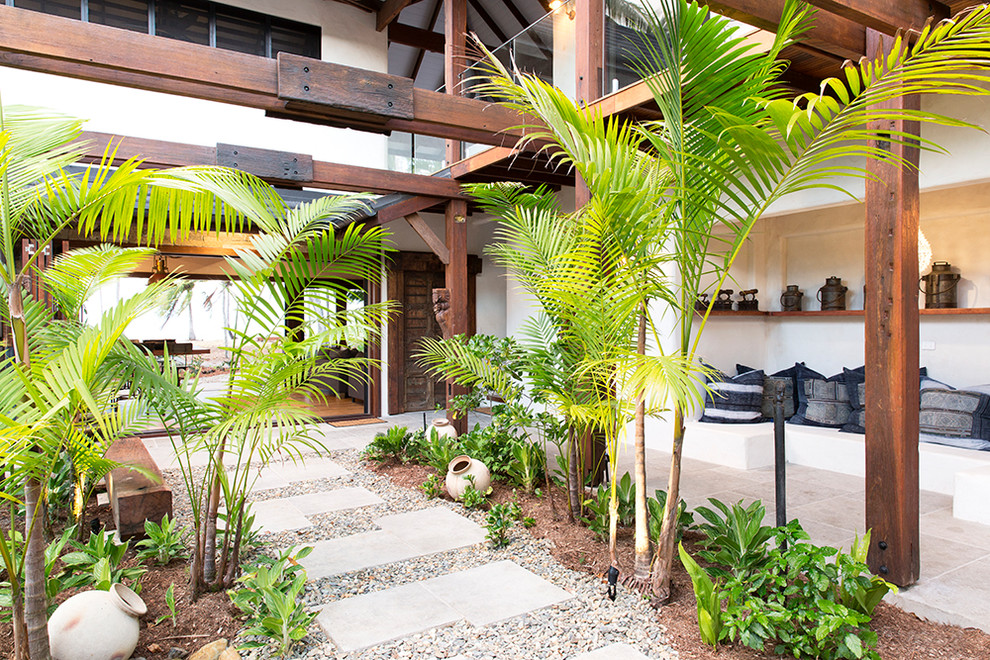 Inspiration for a tropical courtyard full sun garden for summer in Cairns with a garden path.