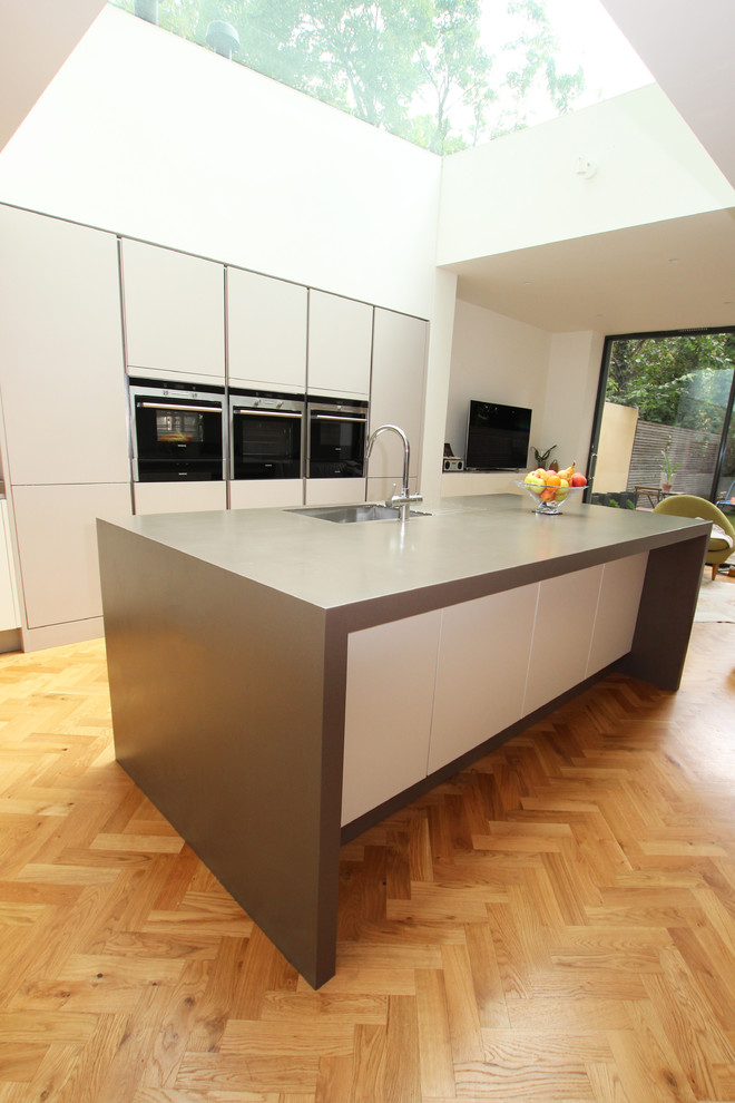 Inspiration for a modern l-shaped kitchen in London with flat-panel cabinets, grey cabinets and with island.