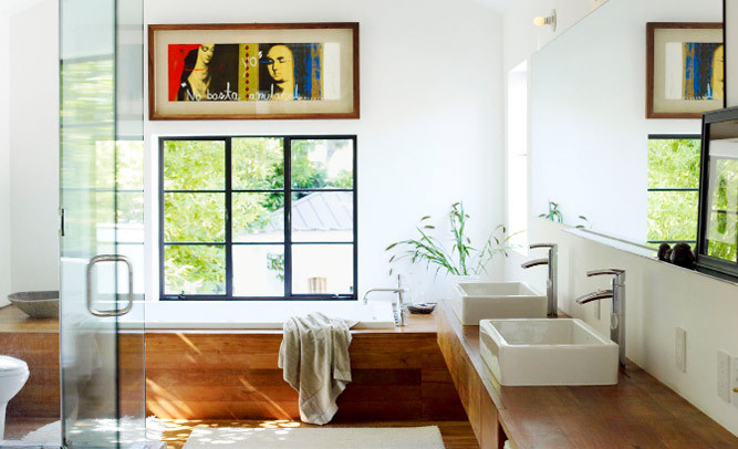 Mid-sized tropical master bathroom in Chicago with flat-panel cabinets, light wood cabinets, a drop-in tub, a corner shower, white walls, light hardwood floors, a vessel sink, wood benchtops, white tile, brown floor, a sliding shower screen, brown benchtops, a double vanity, a floating vanity and a two-piece toilet.