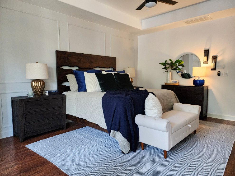 Imagen de dormitorio principal tradicional renovado de tamaño medio con paredes blancas, suelo de madera en tonos medios, suelo marrón, bandeja y boiserie