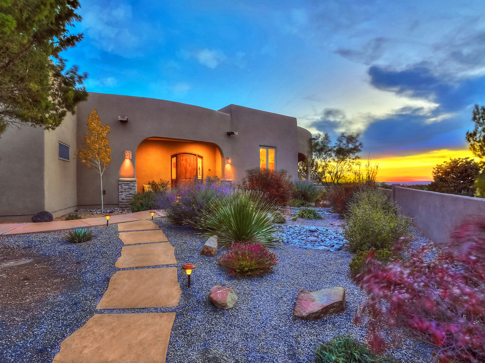Photo of a mid-sized one-storey stucco beige house exterior in Albuquerque with a flat roof.
