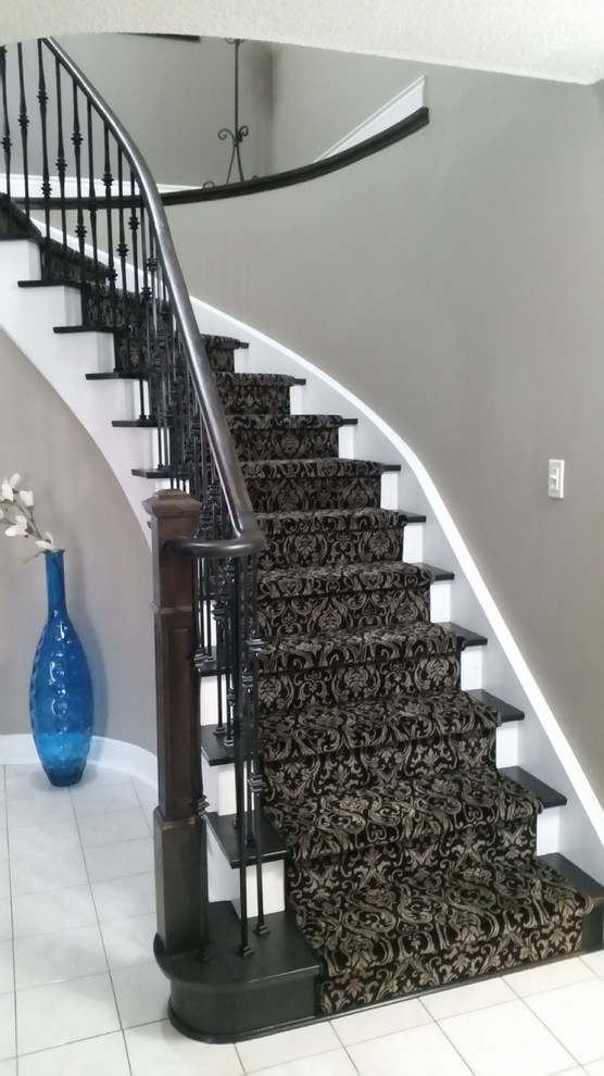 На фото: изогнутая лестница в современном стиле с ступенями с ковровым покрытием и ковровыми подступенками с