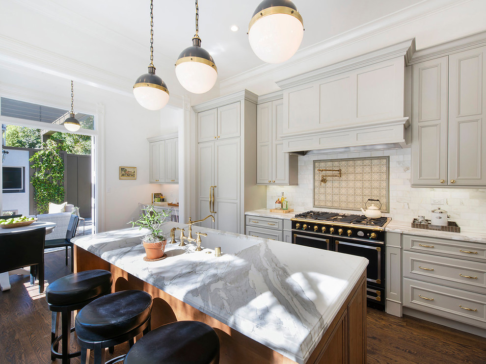 Inspiration for a traditional galley eat-in kitchen in San Francisco with an undermount sink, recessed-panel cabinets, grey cabinets, white splashback, black appliances, dark hardwood floors and with island.