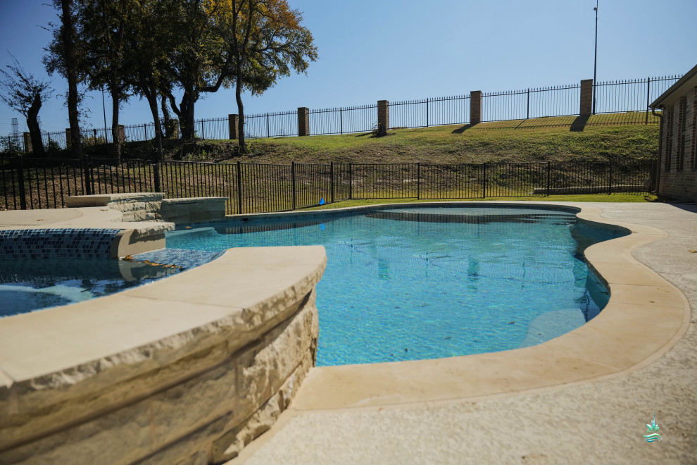 This is an example of a large mediterranean backyard custom-shaped natural pool in Dallas with a hot tub and concrete slab.