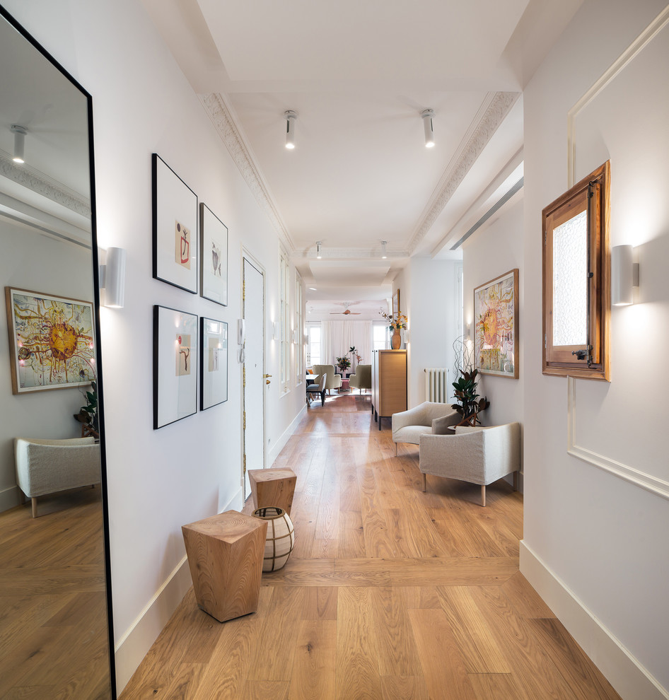 Diseño de hall clásico renovado grande con paredes blancas y suelo de madera clara