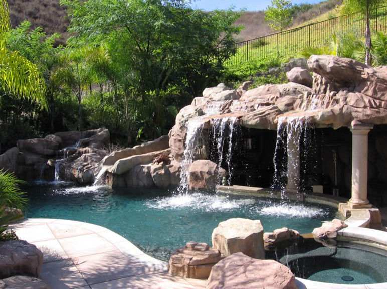 Inspiration for a tropical custom-shaped aboveground pool in Orange County with a water feature.