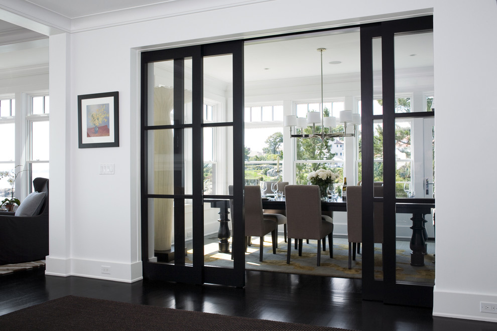 Photo of a transitional separate dining room in Boston with white walls and black floor.