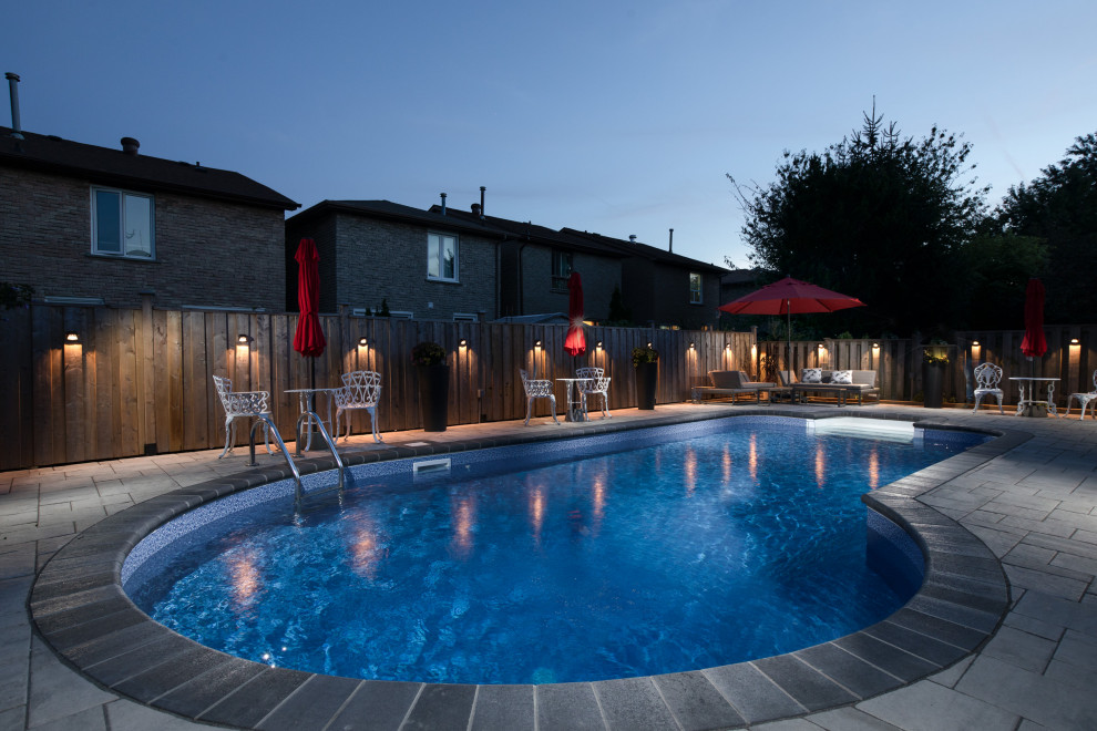 Esempio di una piscina minimalista a "C" di medie dimensioni e dietro casa con paesaggistica bordo piscina e pavimentazioni in cemento