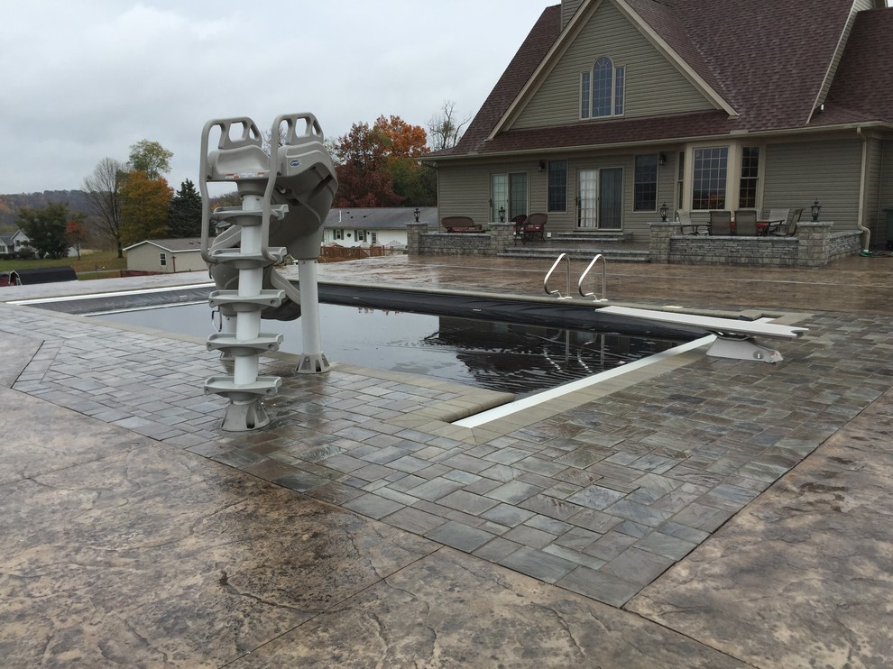 Water slide - large transitional backyard stamped concrete and rectangular lap water slide idea in Cleveland with no cover