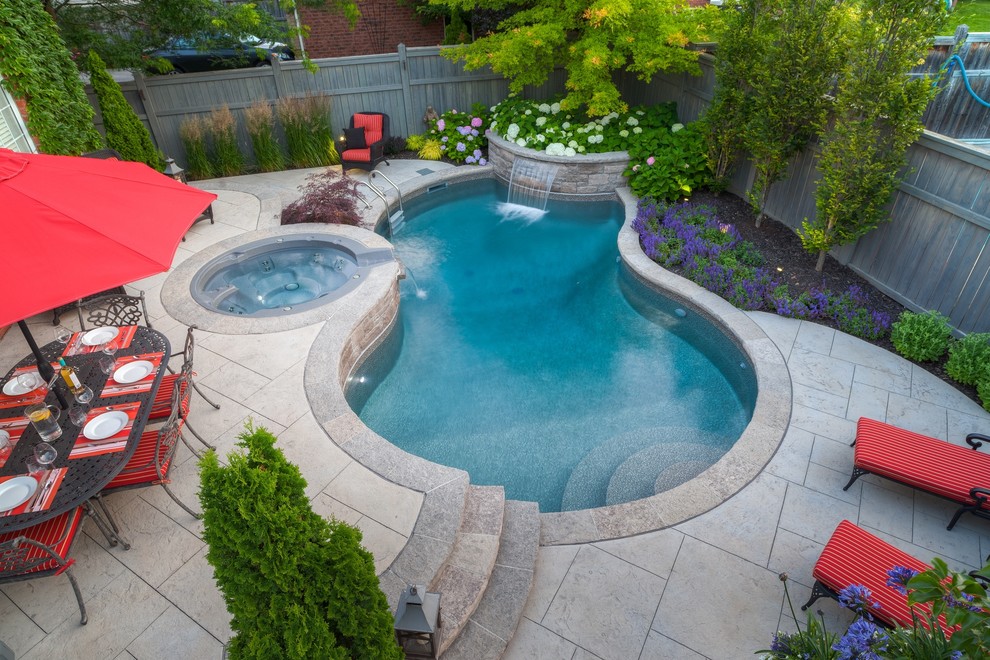 Photo of a small contemporary backyard custom-shaped pool in Toronto with a water feature and stamped concrete.