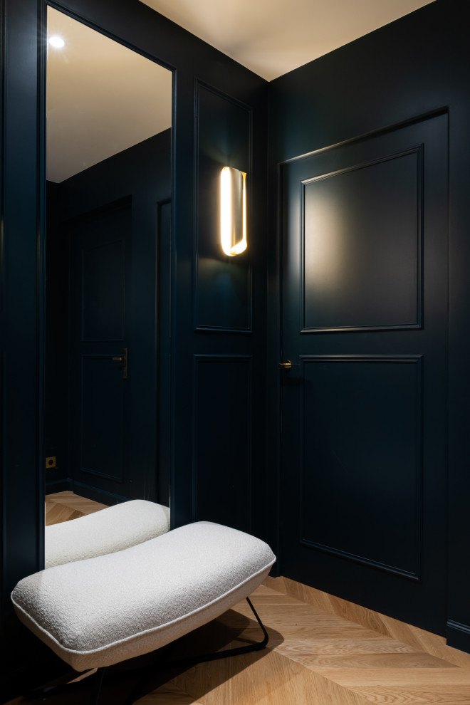 На фото: фойе среднего размера в современном стиле с синими стенами, светлым паркетным полом, одностворчатой входной дверью, синей входной дверью, коричневым полом и панелями на стенах