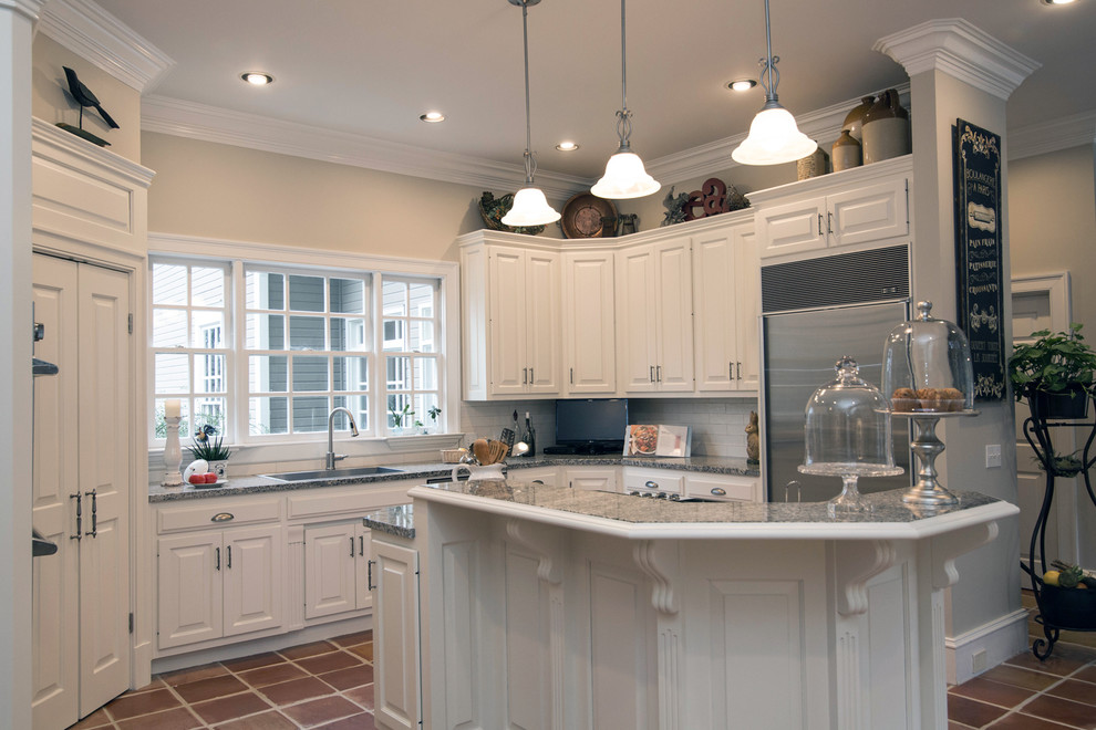 Photo of a mid-sized traditional u-shaped kitchen pantry in Atlanta with a single-bowl sink, raised-panel cabinets, white cabinets, granite benchtops, white splashback, stone tile splashback, stainless steel appliances, terra-cotta floors and with island.