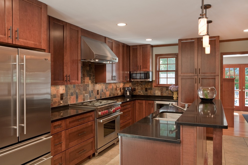 Design ideas for a mid-sized eclectic l-shaped eat-in kitchen in DC Metro with a double-bowl sink, shaker cabinets, dark wood cabinets, granite benchtops, brown splashback, slate splashback, stainless steel appliances, porcelain floors, with island and beige floor.