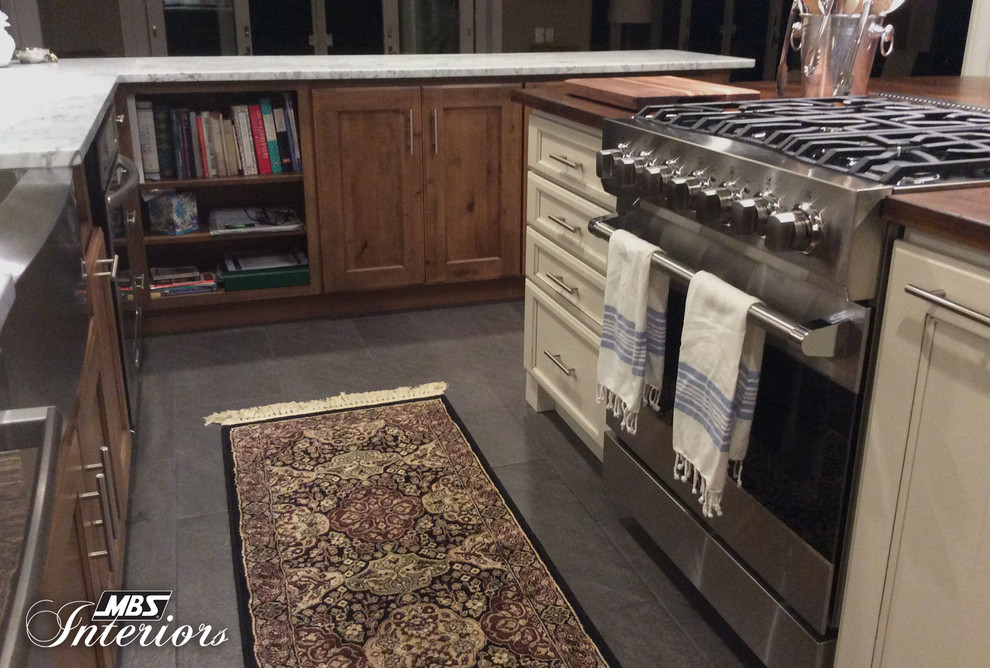 Example of a mid-sized transitional u-shaped ceramic tile and gray floor eat-in kitchen design with a farmhouse sink, recessed-panel cabinets, medium tone wood cabinets, marble countertops, white backsplash, subway tile backsplash, stainless steel appliances and an island