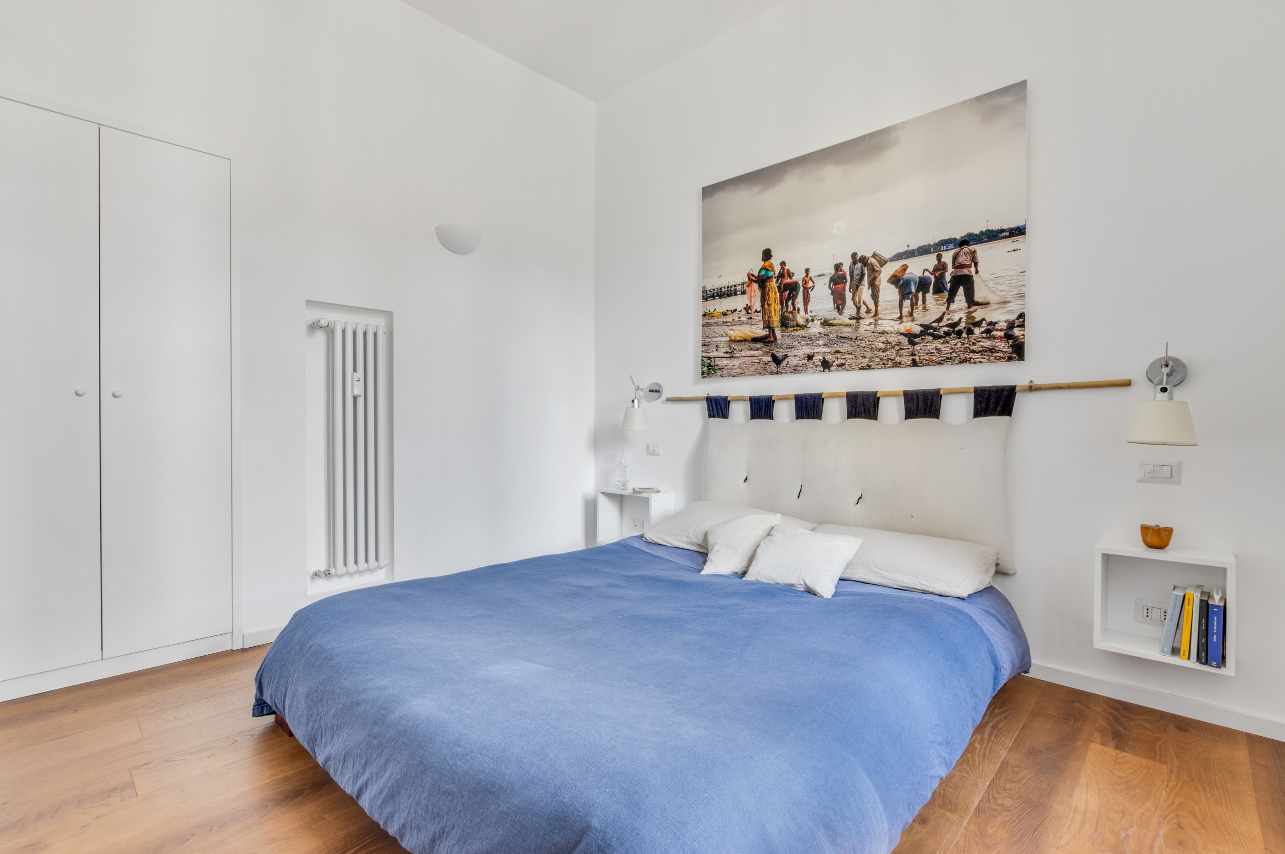 Example of a mid-sized minimalist master dark wood floor and brown floor bedroom design in Rome with white walls